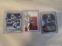 Front view of three rookie cards in top-loaders