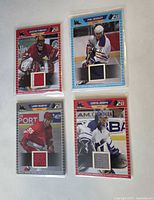 Fronts of four jersey cards in sleeves showing player images and fabric swatches