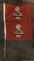 Two red mini Raptors championship flags side by side