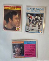 Front view of three sleeved hockey cards