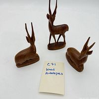 Three carved wood antelopes grouped with lot note visible