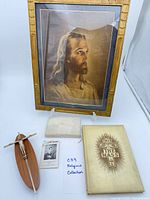 Full lot overview showing framed Jesus lithograph, crucifix, book, plaque, prayer card