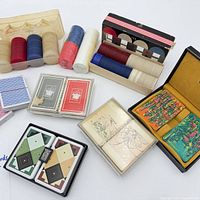 Overall view of poker chips in wooden rack and box, multiple playing card sets