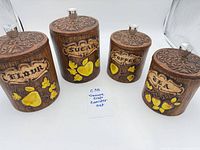 Full view of four Treasure Craft canisters labeled Flour, Sugar, Coffee, Tea