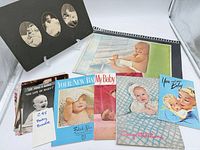 All items laid out: five pamphlets, loose photographs, mounted portraits, color print