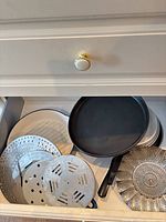 Drawer view with pizza pan, steamer inserts visible