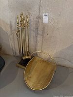 Full view of brass fireplace tool set and log holder