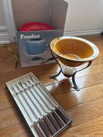 Full lot: boxed fondue set, warming bowl on stand, forks in tray