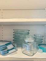 Stack of six rectangular containers, three round containers and glass jar on shelf