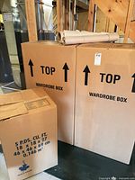 Two wardrobe boxes, one 5 cu ft box, packing paper roll