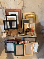 Stack of assorted frames on table, showing variety of materials and sizes