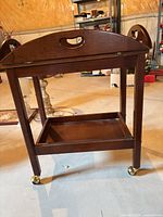 Full view of tea wagon showing top tray, lower shelf and casters