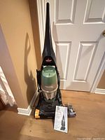 Full view of vacuum with manual and accessory parts