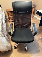 Front view of black high-back swivel office chair with mesh back and fabric seat