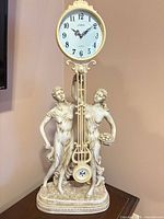Full view of Natelia resin figurine pendulum clock showing overall design and proportion