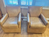 Front view of both tan leather armchairs