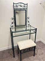Full view of metal vanity with glass top, mirror, and bench