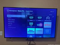 Front view of Westinghouse 70" TV powered on to Roku home screen