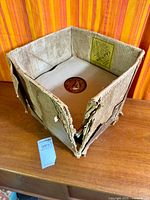Damaged cardboard box containing stack of 78 rpm records in sleeves