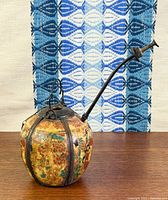 Full view of painted spherical body with curved stem