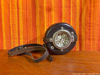 Front view of watchman’s clock showing dial and leather case