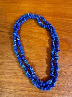 Full view of continuous lapis lazuli nugget necklace laid flat