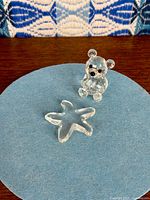 Both Swarovski figurines displayed together on blue felt