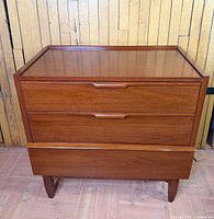 Front view showing three drawers and tapered legs