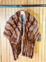 Front view of brown mink fur stole hanging on hanger