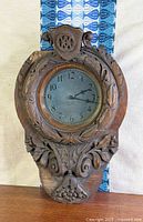 Front view of carved wood wall clock
