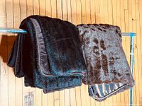 Both faux fur throws draped over rack showing colours and edging