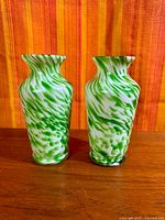 Front view of both green and white splatter vases