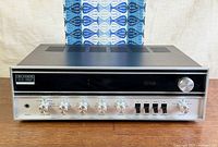 Front angled view of Fisher 202 receiver showing faceplate, knobs, push buttons and case