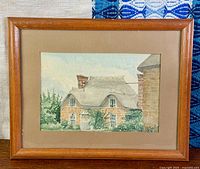 Front view of framed watercolor cottage painting