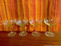 Four yellow Cameo depression glass coupes lined up, full view