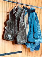 Group of four coats hanging on rail