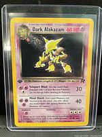 Front of Dark Alakazam holographic card in top loader