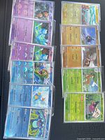 Overview showing two columns of sleeved rainbow-holo Pokémon cards (total visible eight), confirming quantity and protective sleeves