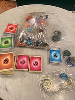 overview showing sealed energy card packs, bag of dice, bags of coins