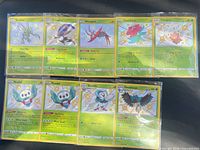 Full view of nine sleeved Shiny Vault cards in two rows