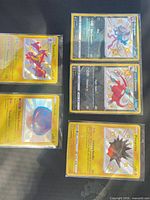 Five sleeved shiny Pokémon cards displayed