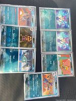 All nine sleeved Pokémon holofoil cards laid out