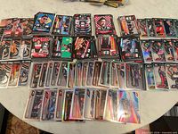 Wide view of entire spread of 200+ Topps Formula 1 and motorsport cards on table