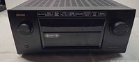 Front view of Denon AVR-X7200W receiver showing knobs, display door, and branding