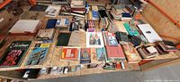 Overview of multiple stacks of vintage books, magazines and pamphlets spread across table