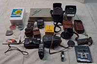 Overview of entire lot laid out showing camera, flashes, cases, filters, mounts, booklets