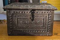 Front view showing brass repousse panels and latch