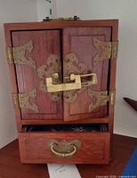 Front view closed showing brass hardware and bottom drawer