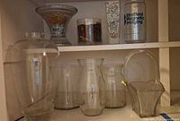Shelf with compote bowl, cylinder vases, marbles vase, branded vase, four bulbous vases, twisted vase and basket