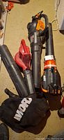 Two Worx leaf blowers and Worx bag on floor